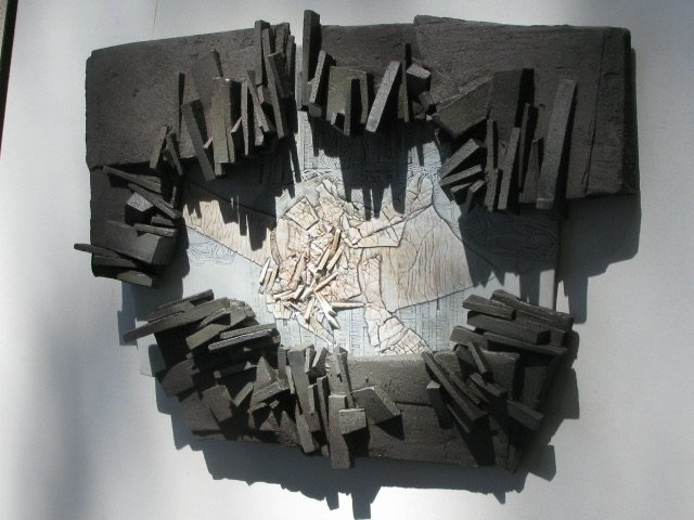 Bas-relief en grès gris dont les lamelles encadrent un centre de porcelaine craquelée